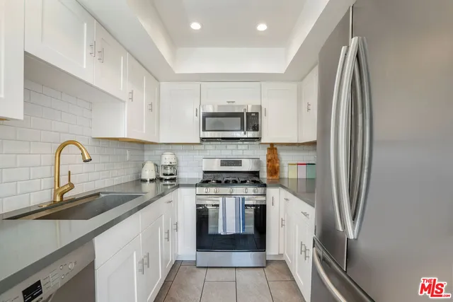 a kitchen with stainless steel appliances granite countertop a stove sink and refrigerator