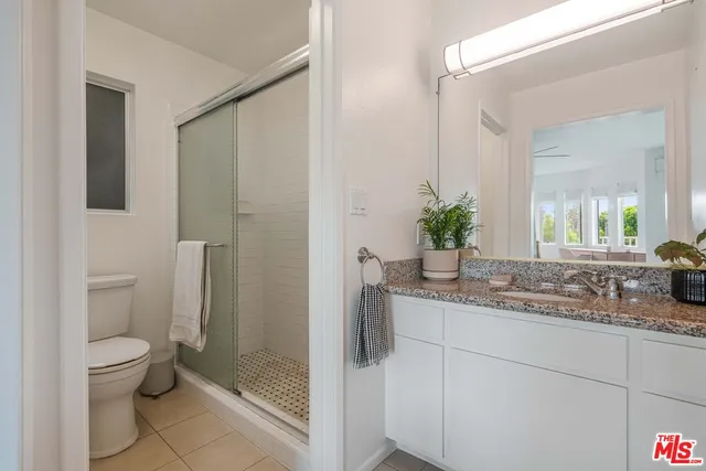 a bathroom with a granite countertop sink a toilet and shower