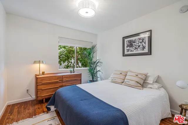 a bedroom with a bed and a painting on the wall