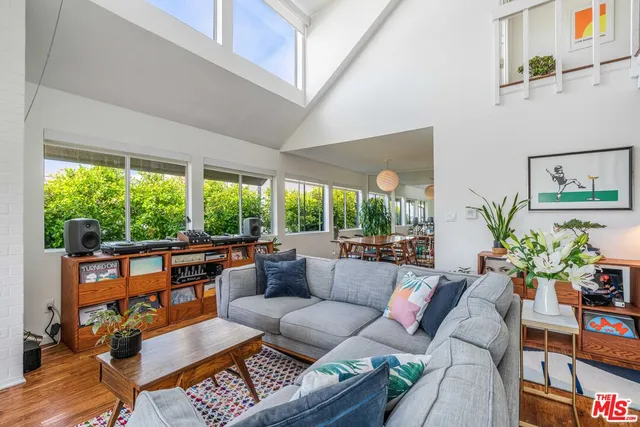 a living room with patio furniture and a potted plant