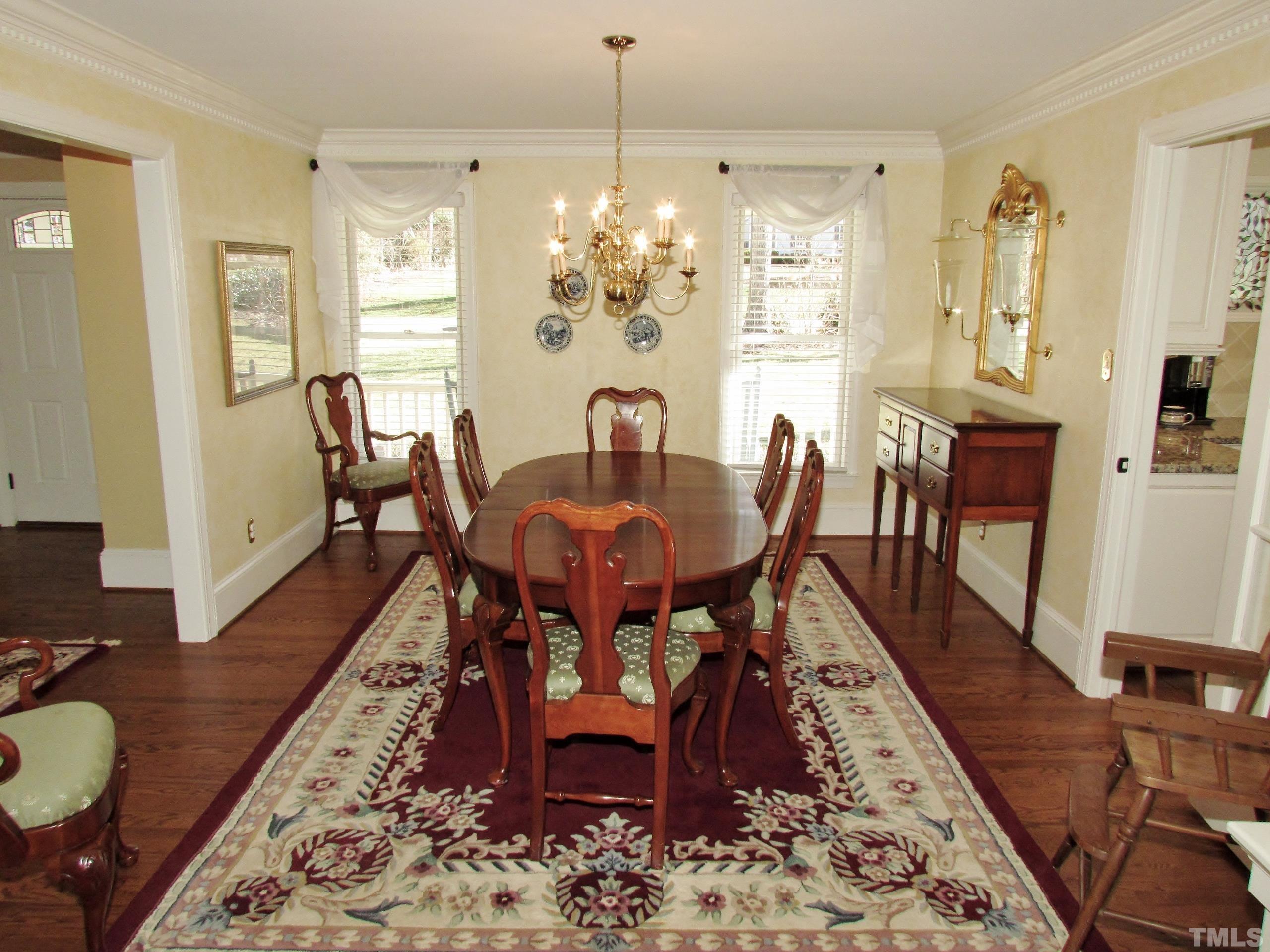 12001 Pembridge Lane Raleigh, NC 27613 - Photo 14 of 53 a dining room with furniture a rug a rug and wooden floor