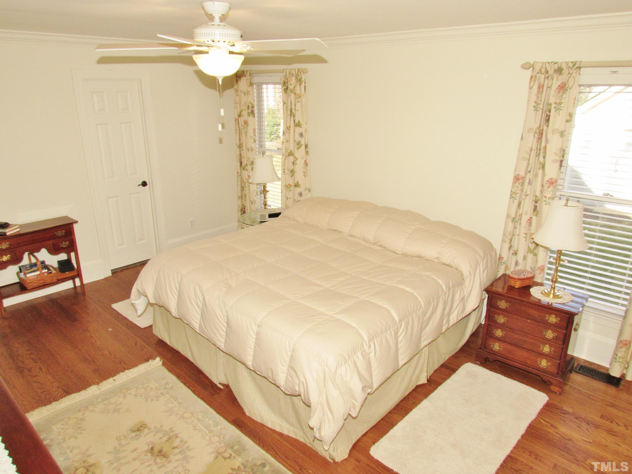 12001 Pembridge Lane Raleigh, NC 27613 - Photo 24 of 53 a bedroom with a bed chandelier and a window
