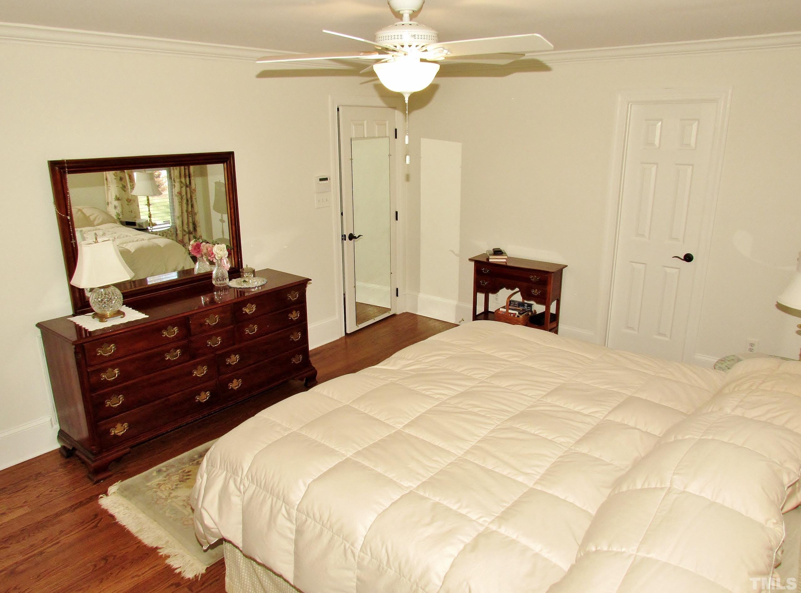 12001 Pembridge Lane Raleigh, NC 27613 - Photo 25 of 53 a bedroom with a bed and a chandelier