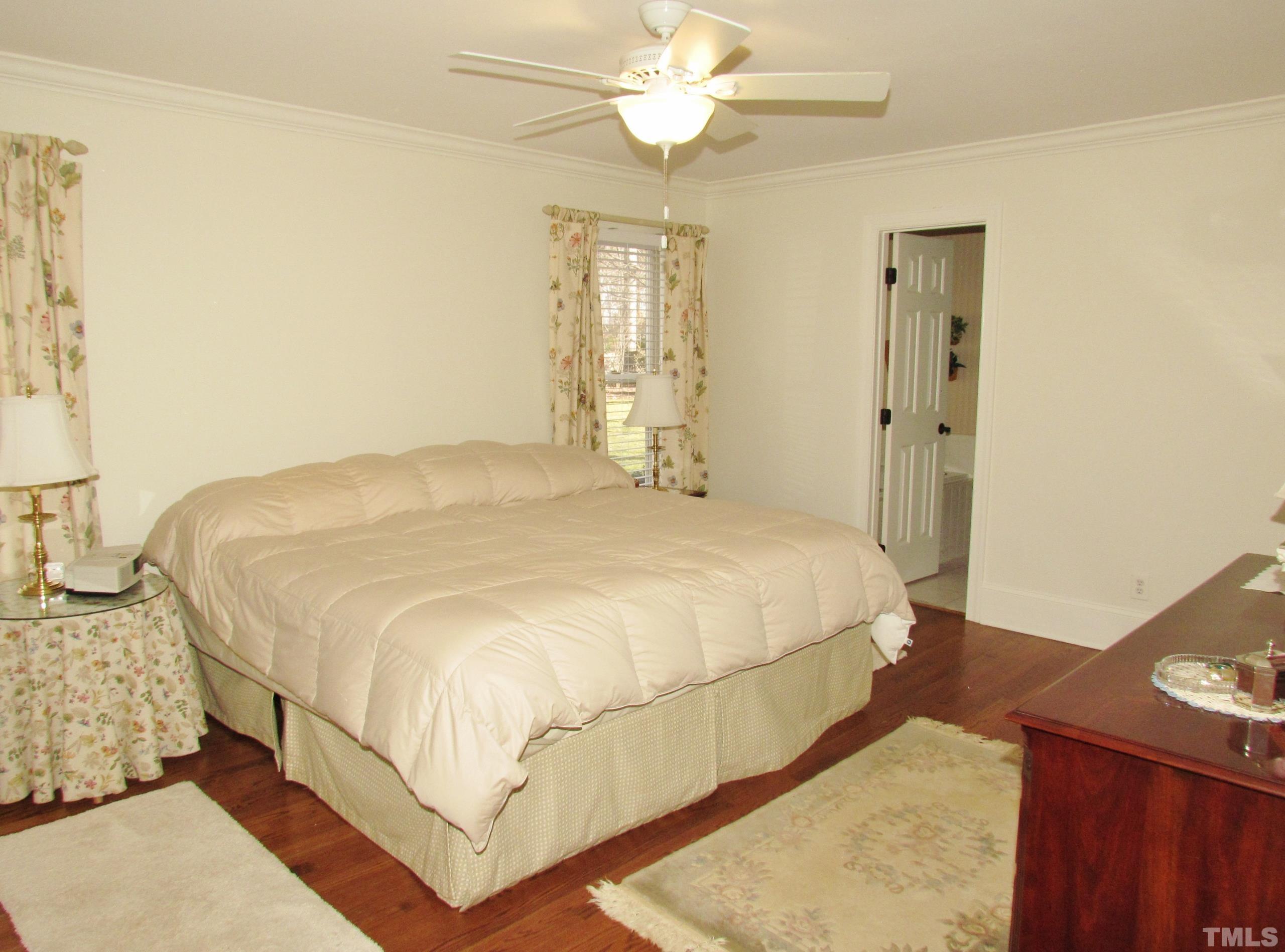 12001 Pembridge Lane Raleigh, NC 27613 - Photo 26 of 53 a bedroom with a bed and a chandelier