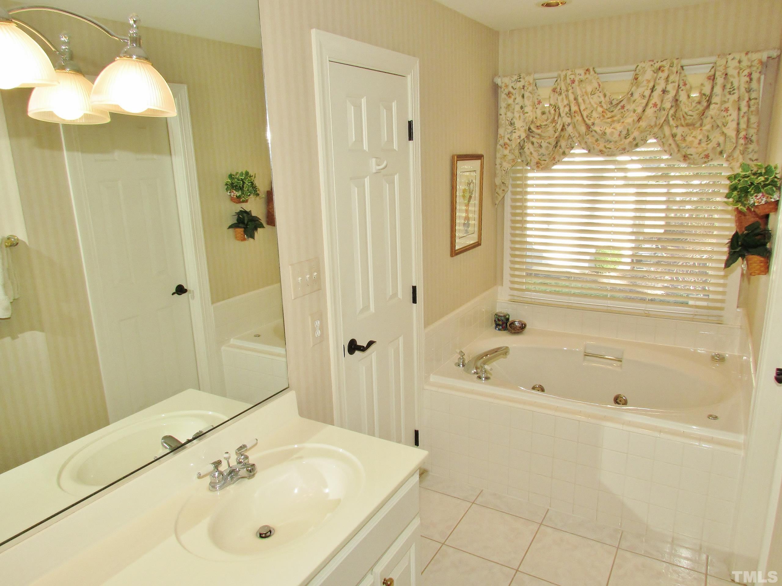 12001 Pembridge Lane Raleigh, NC 27613 - Photo 28 of 53 a bathroom with a bath tub and a sink