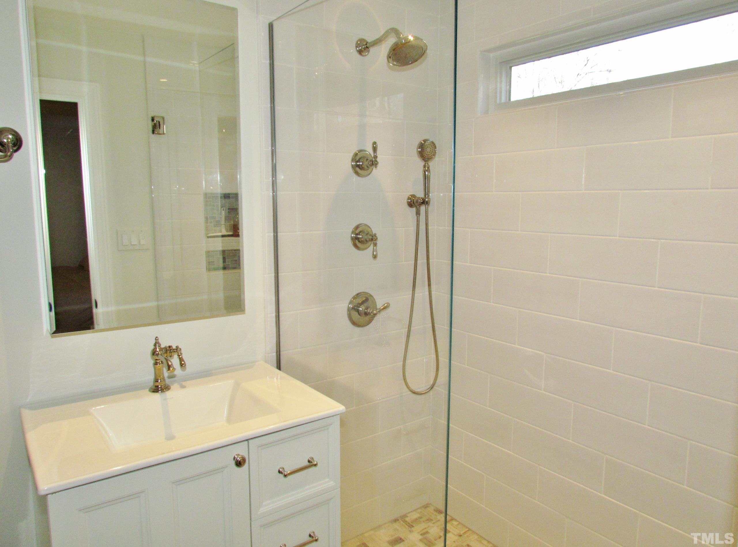 12001 Pembridge Lane Raleigh, NC 27613 - Photo 29 of 53 a bathroom with a sink shower and a mirror