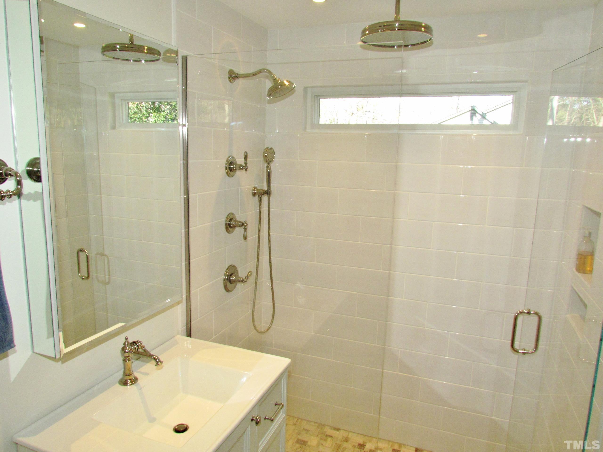 12001 Pembridge Lane Raleigh, NC 27613 - Photo 30 of 53 a bathroom with a shower a sink and a mirror