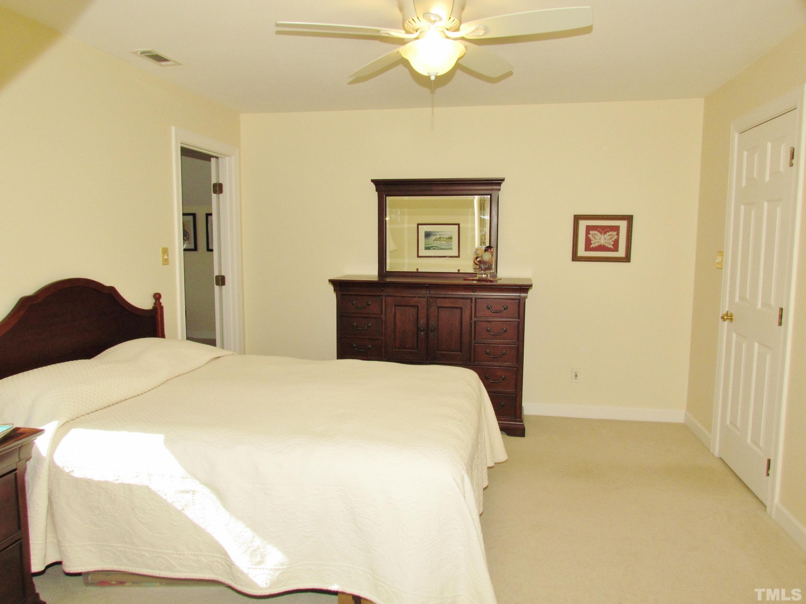 12001 Pembridge Lane Raleigh, NC 27613 - Photo 32 of 53 a bedroom with a bed and a chandelier