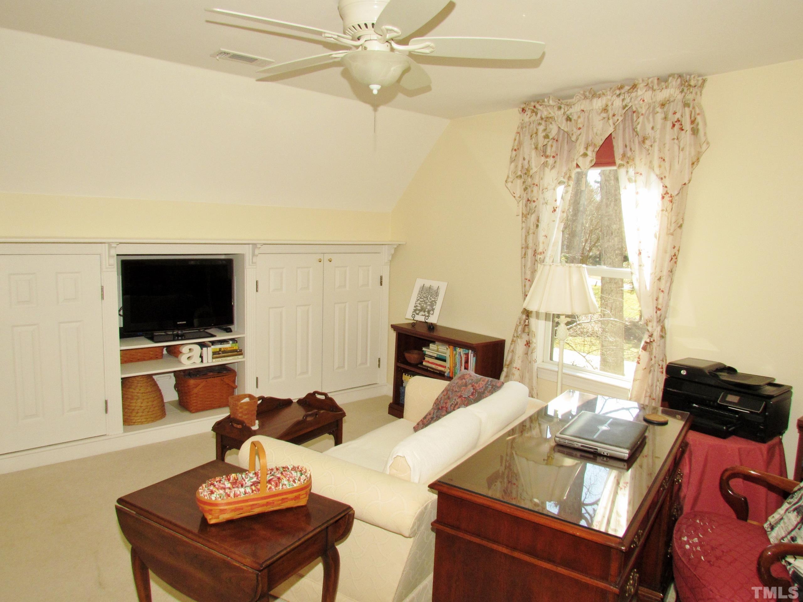 12001 Pembridge Lane Raleigh, NC 27613 - Photo 35 of 53 a living room with furniture and a flat screen tv