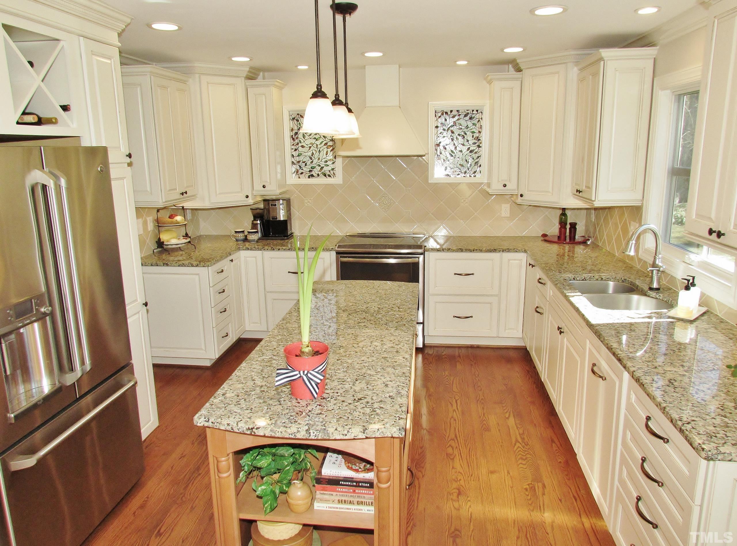 12001 Pembridge Lane Raleigh, NC 27613 - Photo 8 of 53 a large kitchen with stainless steel appliances granite countertop a lot of counter space and wooden floor