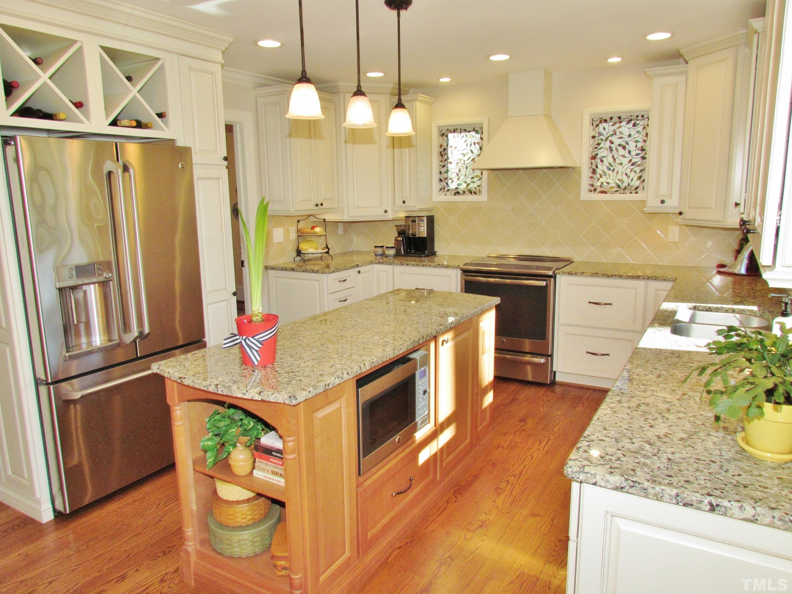 12001 Pembridge Lane Raleigh, NC 27613 - Photo 9 of 53 a kitchen with stainless steel appliances granite countertop a sink a stove and a refrigerator