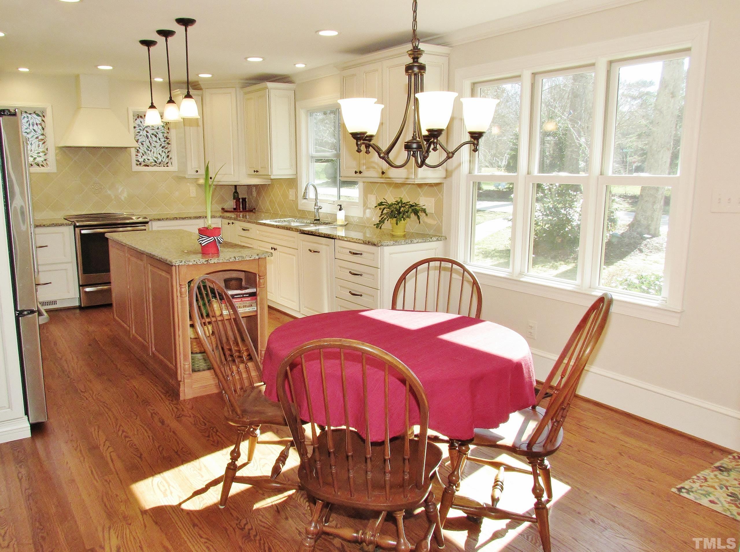 12001 Pembridge Lane Raleigh, NC 27613 - Photo 10 of 53 a dining room with furniture a chandelier and wooden floor