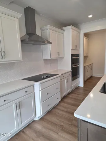 a kitchen with granite countertop white cabinets and white appliances
