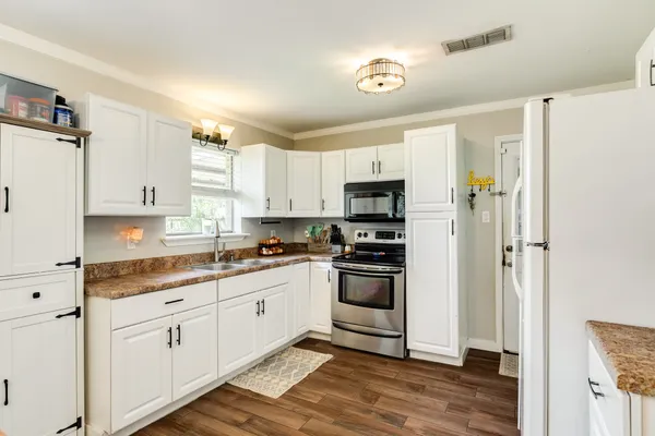 a kitchen with stainless steel appliances granite countertop a refrigerator and a stove top oven