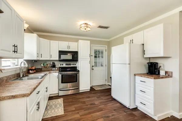 a kitchen with white cabinets and stainless steel appliances
