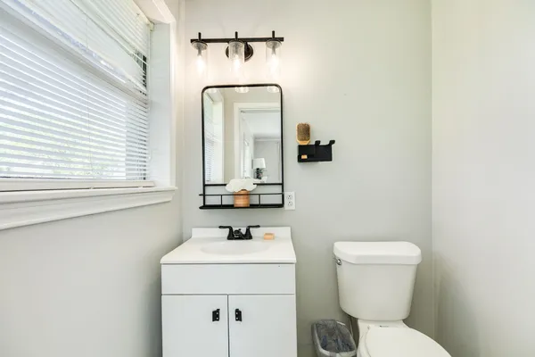 a bathroom with a toilet sink and mirror