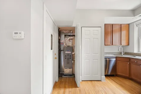a view of a kitchen from the hallway with a sink and wooden floor