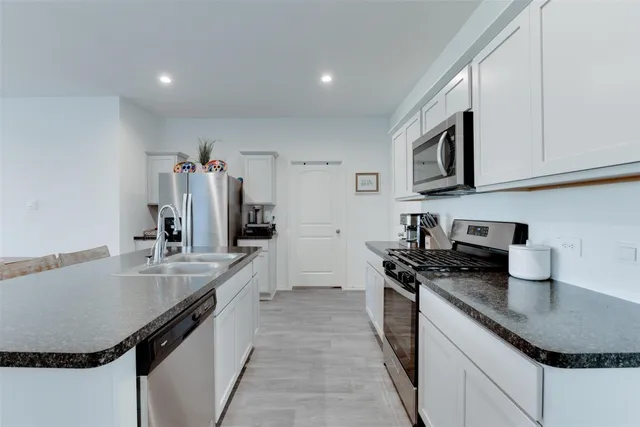 a room with kitchen island a sink table and chairs