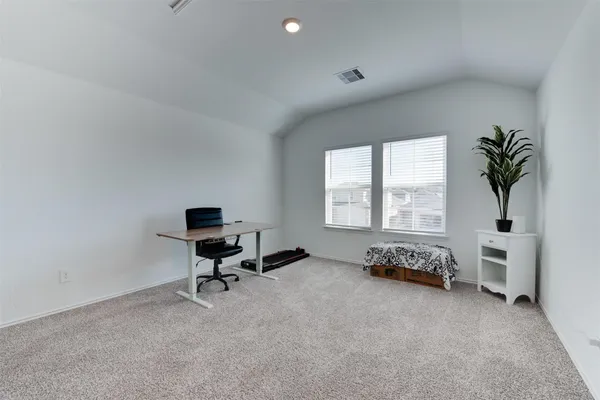 a view of a workspace with furniture and a window