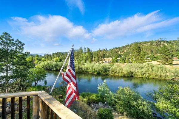 a backyard of a house with lots of green space and lake view