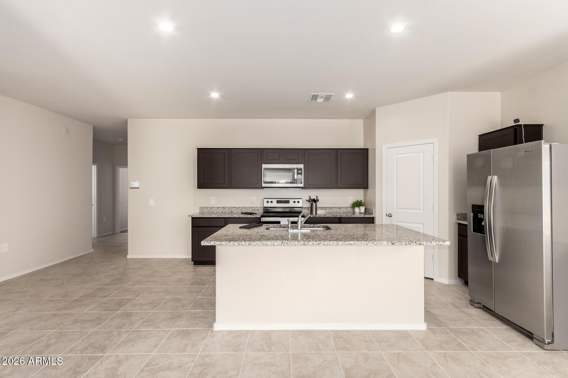 5065 East Emery Road San Tan Valley, AZ 85143 - Photo 11 of 33 a kitchen with stainless steel appliances granite countertop a sink stove and refrigerator