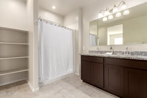 a bathroom with a granite countertop sink a mirror and a shower