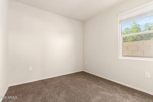 an empty room with windows and bathroom