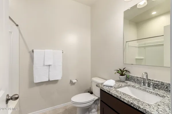a bathroom with a granite countertop sink a toilet and bathtub