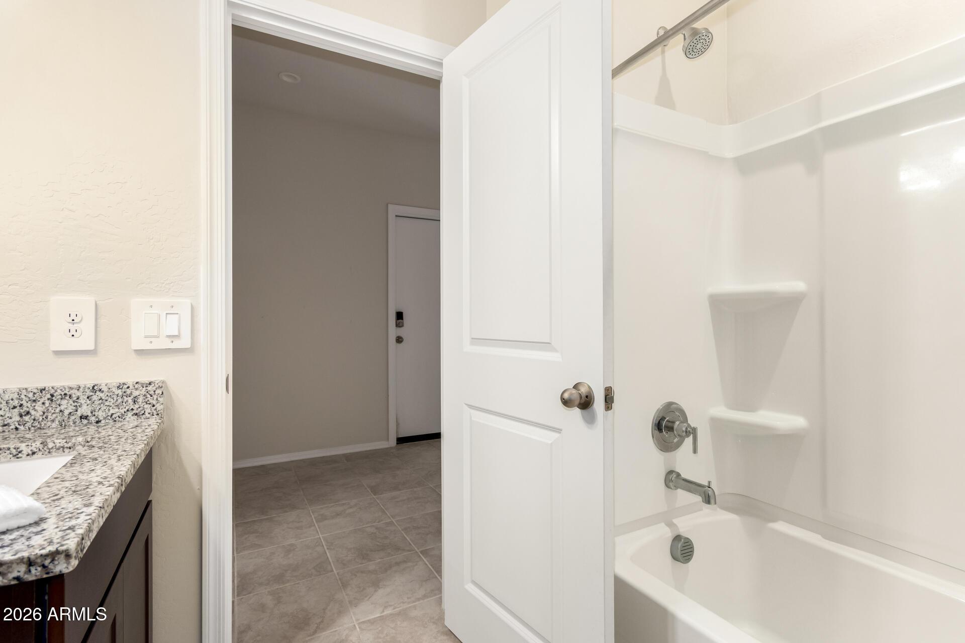 5065 East Emery Road San Tan Valley, AZ 85143 - Photo 22 of 33 a bathroom with a granite countertop sink a toilet and bathtub