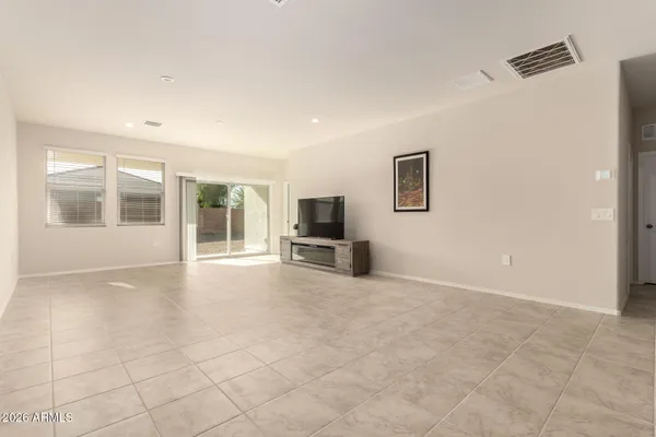 an empty room with windows and fireplace