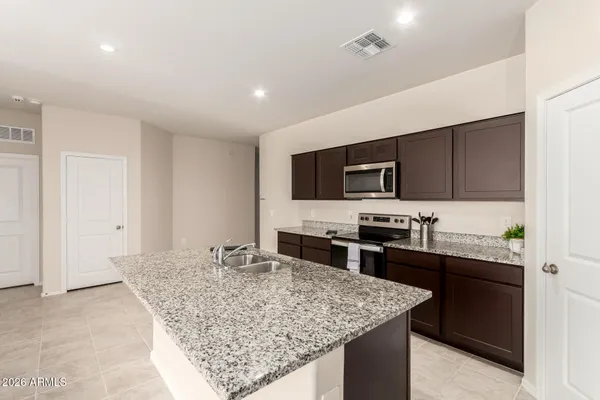a kitchen with stainless steel appliances granite countertop a sink dishwasher stove top oven and refrigerator