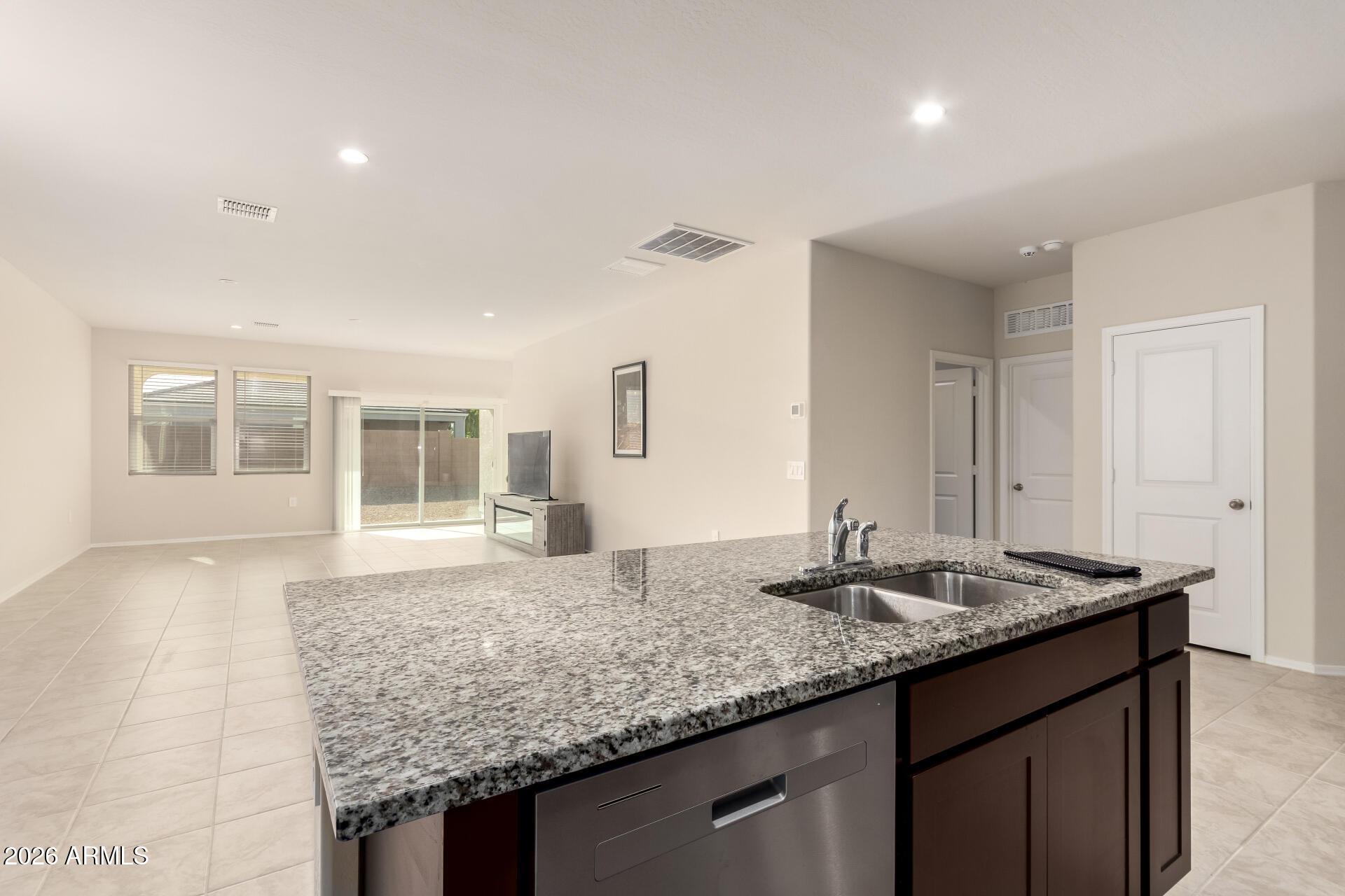 5065 East Emery Road San Tan Valley, AZ 85143 - Photo 9 of 33 a kitchen with granite countertop kitchen island a sink appliances and a counter space