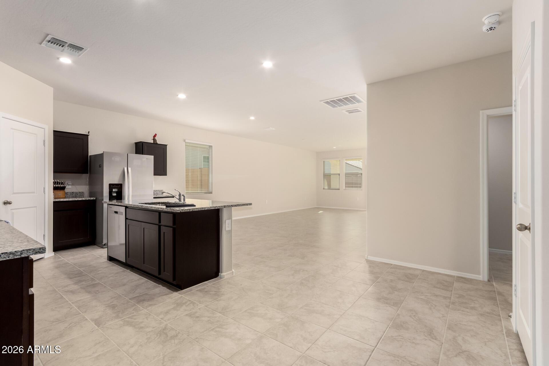5065 East Emery Road San Tan Valley, AZ 85143 - Photo 10 of 33 a large room with kitchen island a sink a counter top space stainless steel appliances and cabinets
