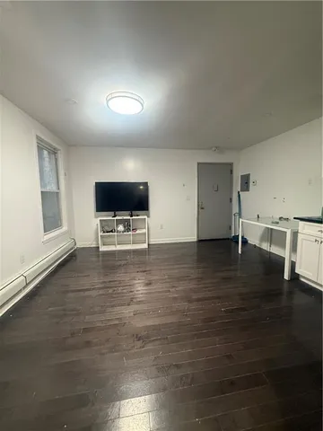 a view of empty room with wooden floor and windows