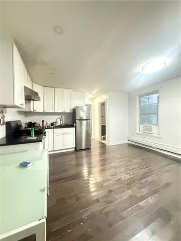 a kitchen with granite countertop a stove a sink and a refrigerator