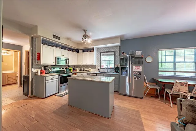 a kitchen with a table chairs refrigerator and cabinets