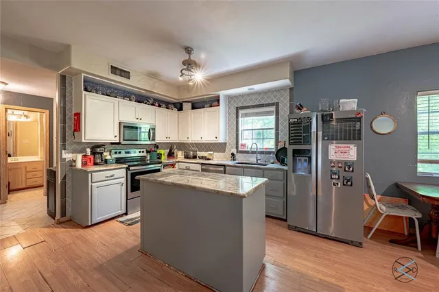a kitchen with cabinets and wooden floor