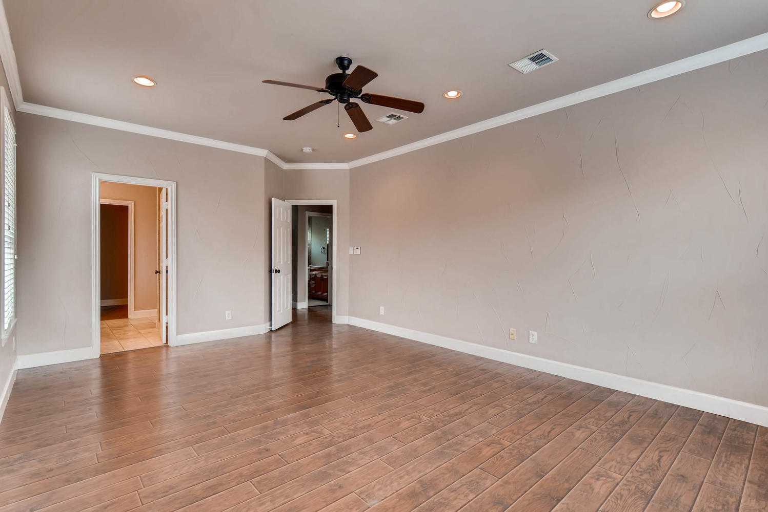 906 Juniper Street Austin, TX 78702 - Photo 16 of 28 a view of an empty room with wooden floor and a ceiling fan