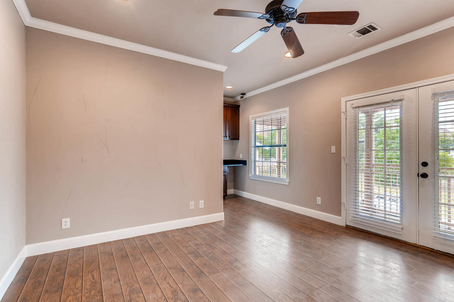 906 Juniper Street Austin, TX 78702 - Photo 19 of 28 an empty room with wooden floor chandelier fan and windows