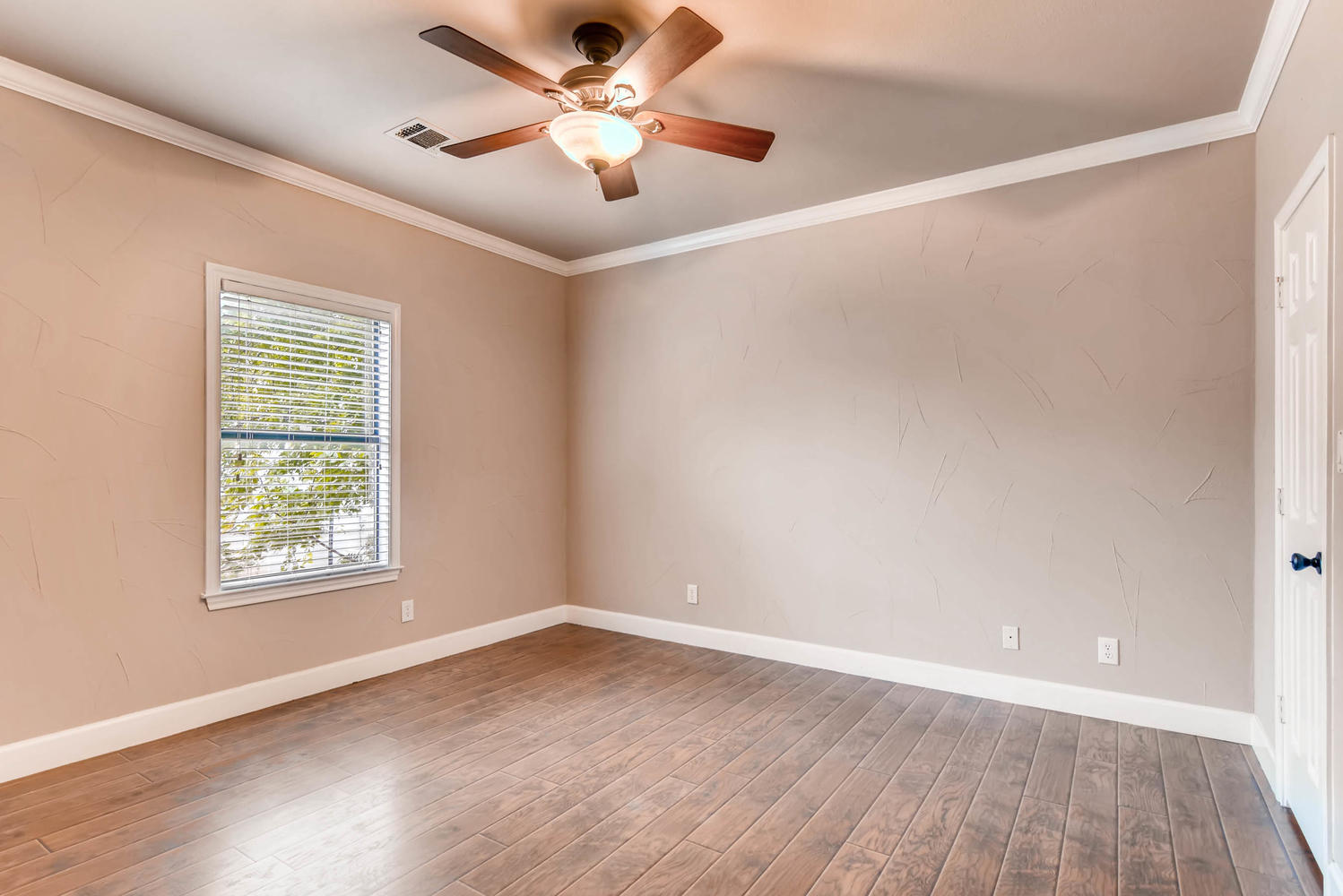 906 Juniper Street Austin, TX 78702 - Photo 21 of 28 an empty room with wooden floor ceiling fan and windows