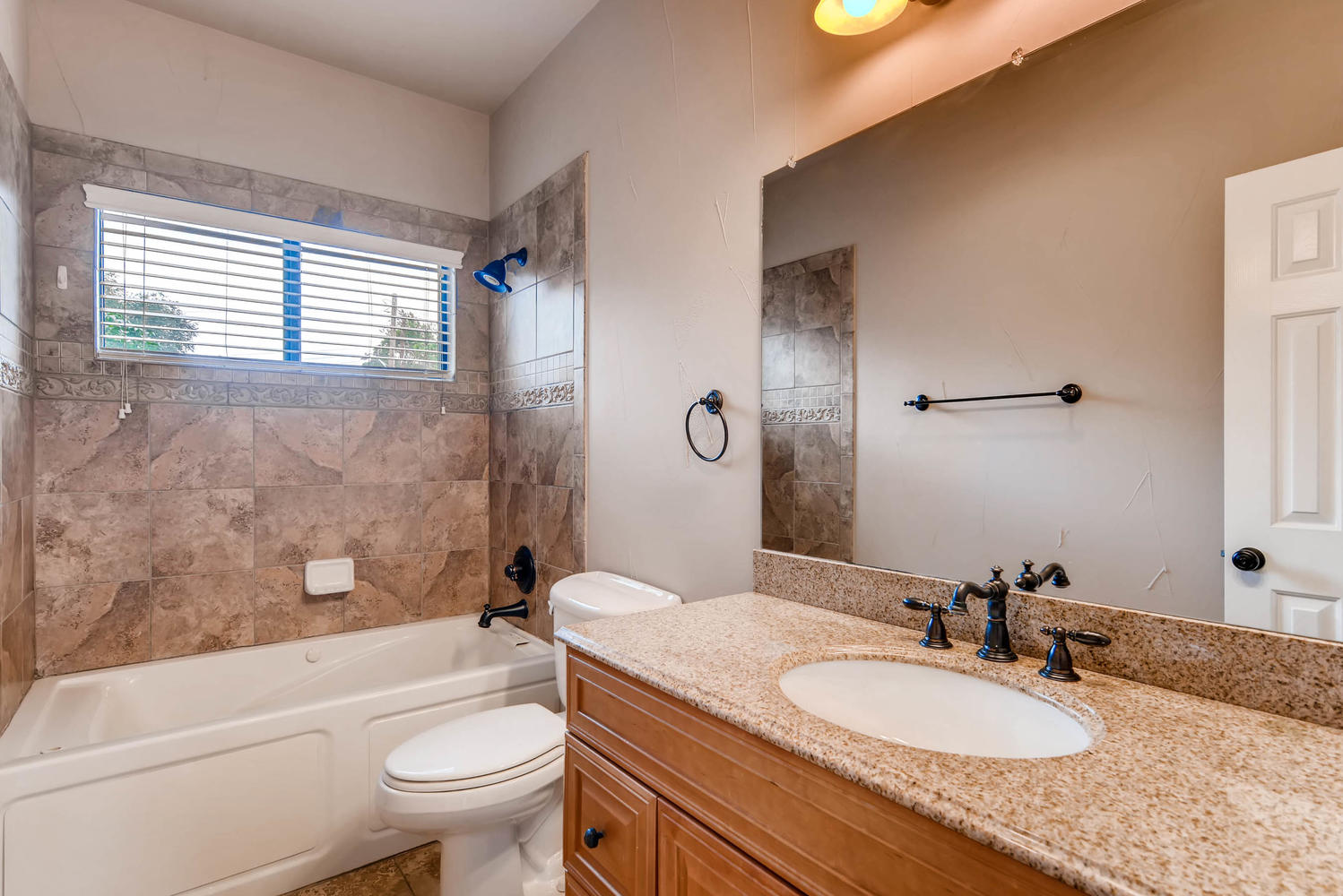 906 Juniper Street Austin, TX 78702 - Photo 22 of 28 a bathroom with a granite countertop sink toilet mirror and bathtub