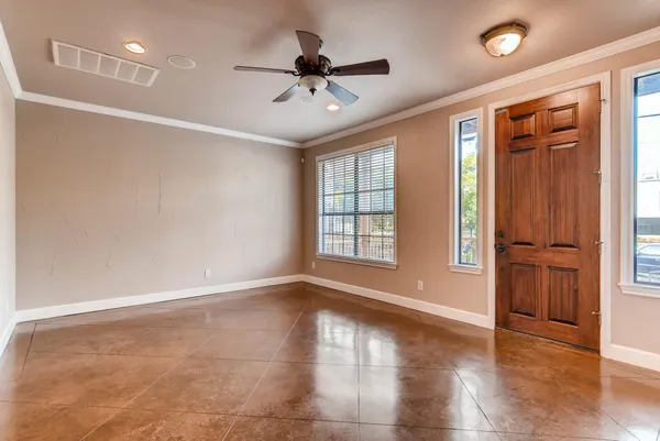 a view of an empty room with a window and wooden floor