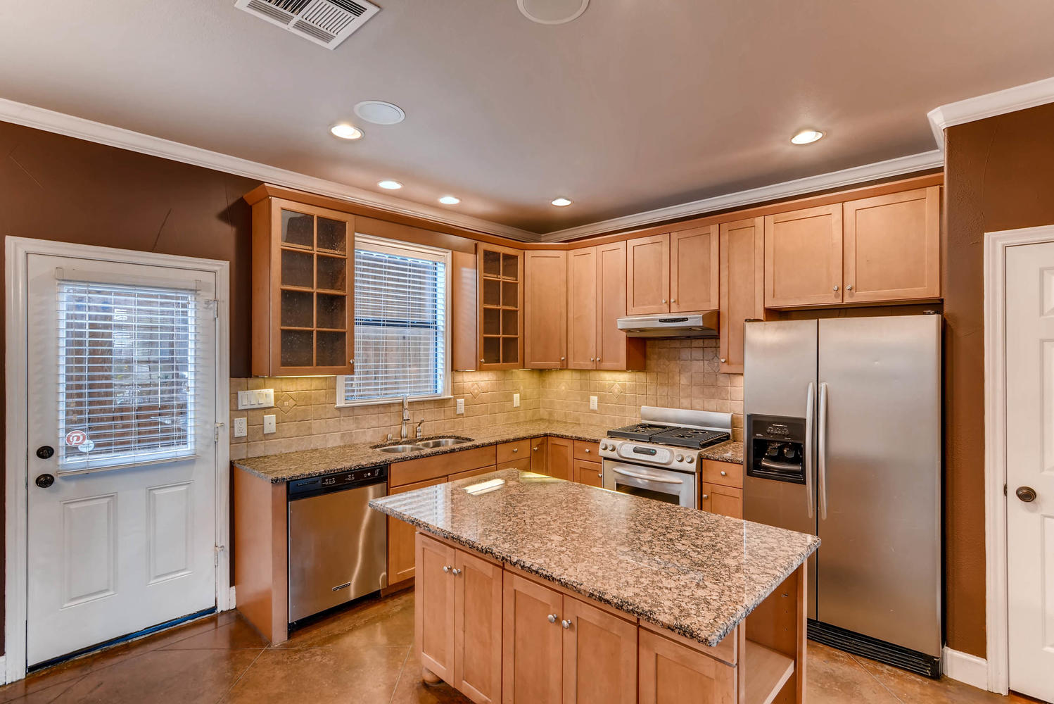 906 Juniper Street Austin, TX 78702 - Photo 7 of 28 a kitchen with granite countertop kitchen island wooden cabinets a refrigerator and a sink
