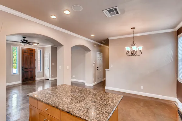 a view of a hallway with wooden floor and a chandelier
