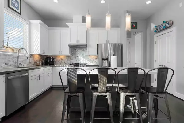 a kitchen with granite countertop white cabinets and stainless steel appliances