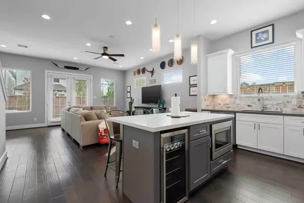 a kitchen with kitchen island a stove a sink a dining table and chairs