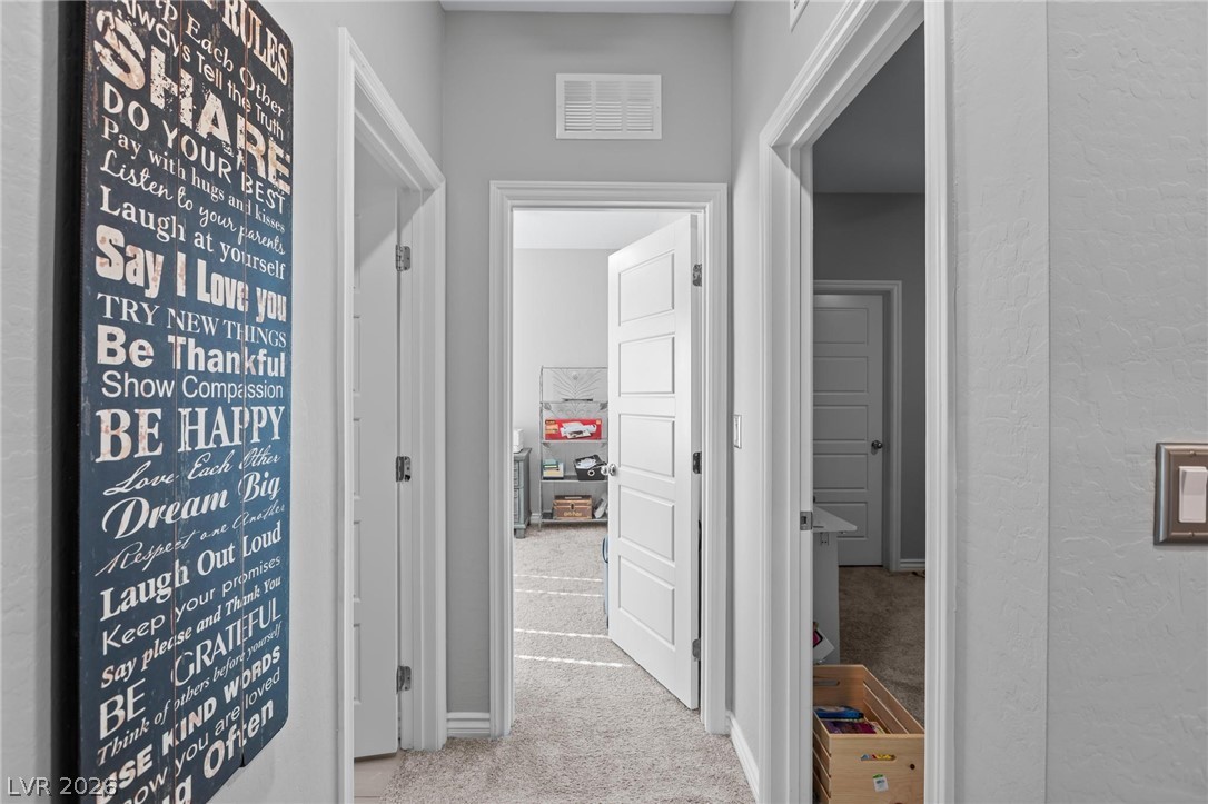 7310 North Decatur Boulevard, Unit 4 North Las Vegas, NV 89084 - Photo 17 of 35 A well-lit interior hallway offers clean lines and textured walls.