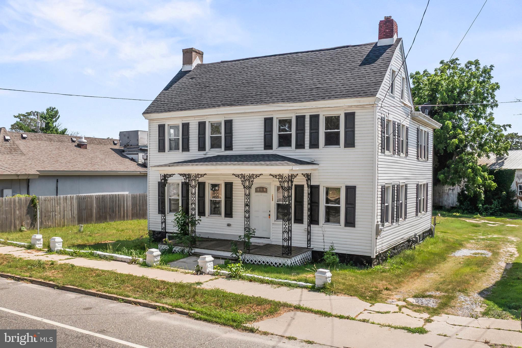 348 Main Street Cedarville, NJ 08311 - Photo 2 of 9 a view of a white house with large windows and a small yard