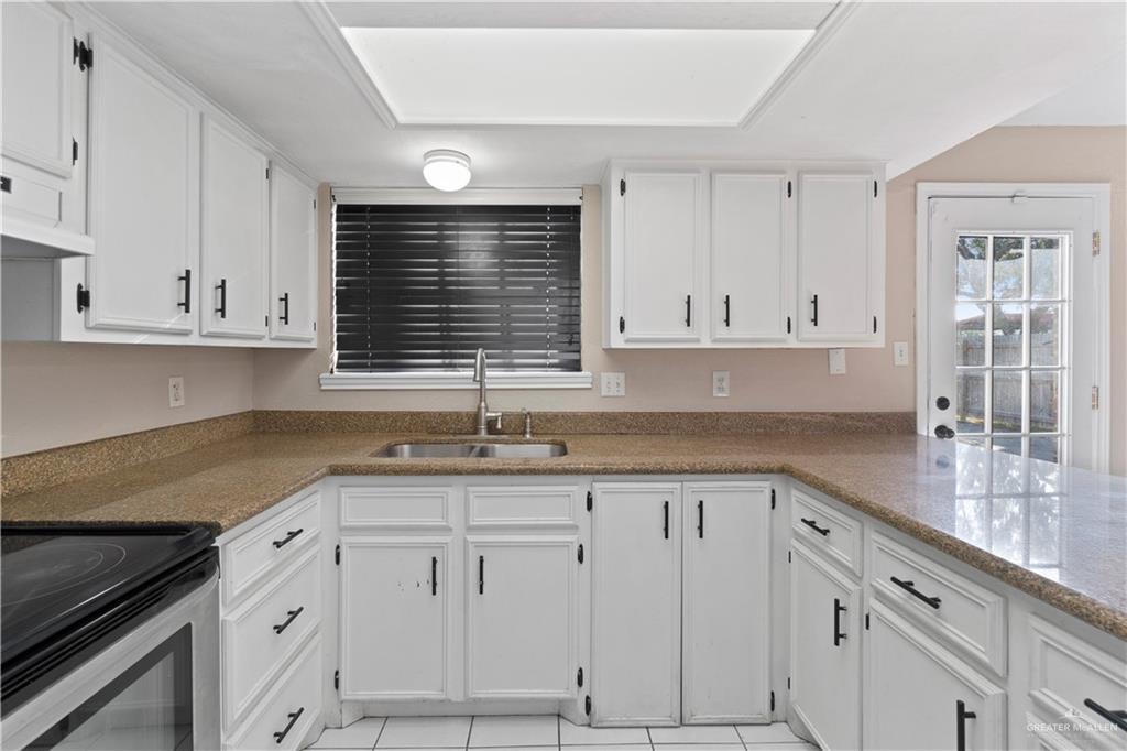 7412 North 19th Street McAllen, TX 78504 - Photo 7 of 22 a kitchen with granite countertop white cabinets and white appliances
