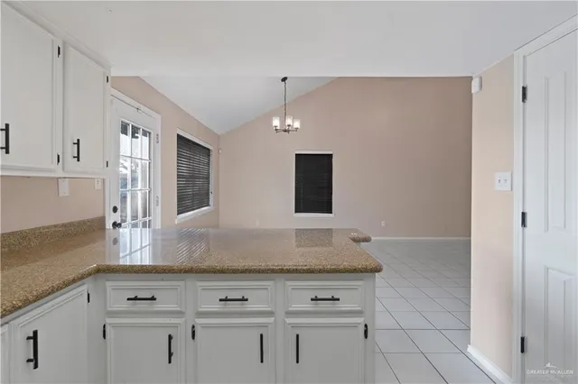a kitchen with granite countertop white cabinets and white appliances